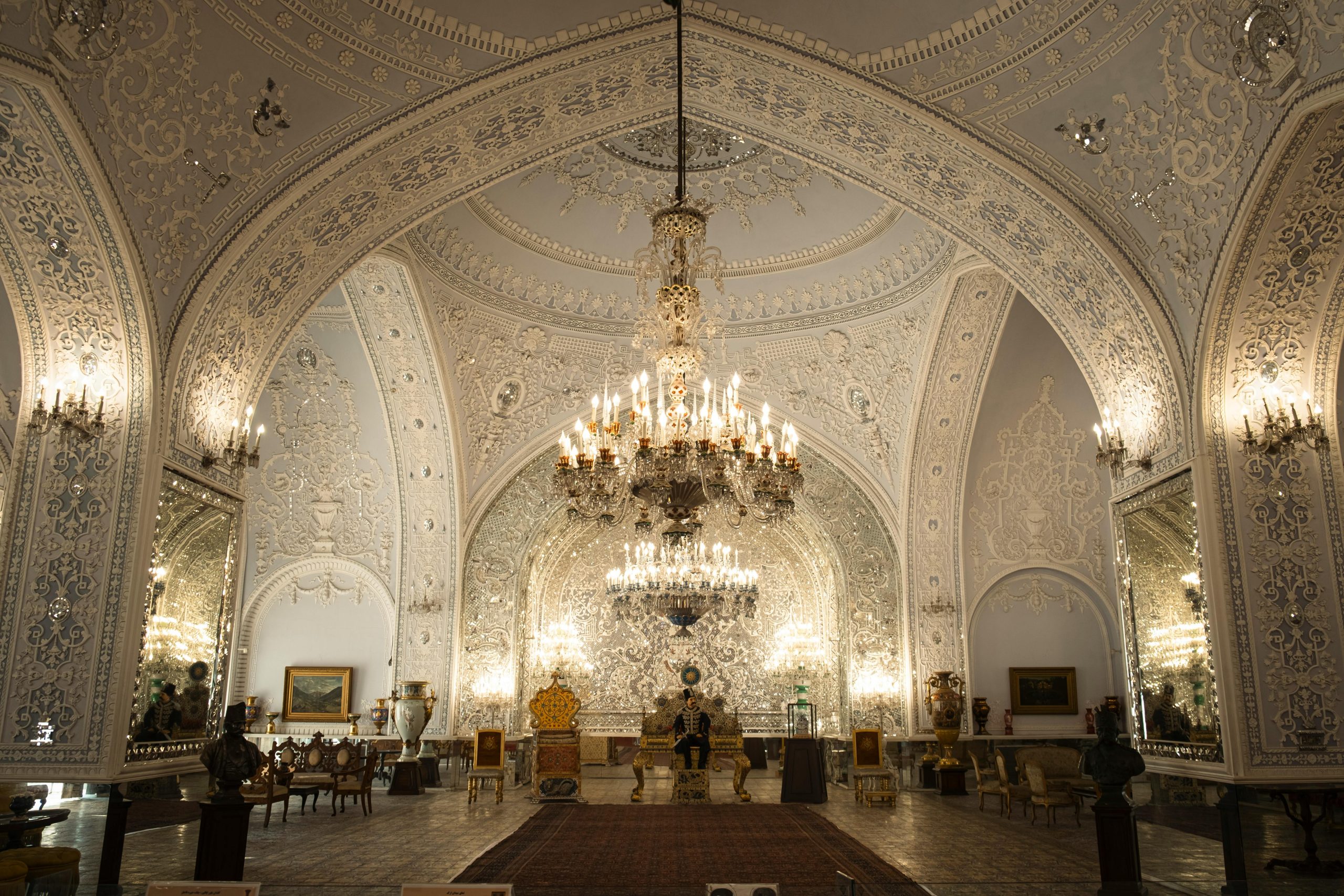 Intricate details of an opulent room in the Golestan Palace, Tehran, showcasing stunning decor and grand chandeliers.