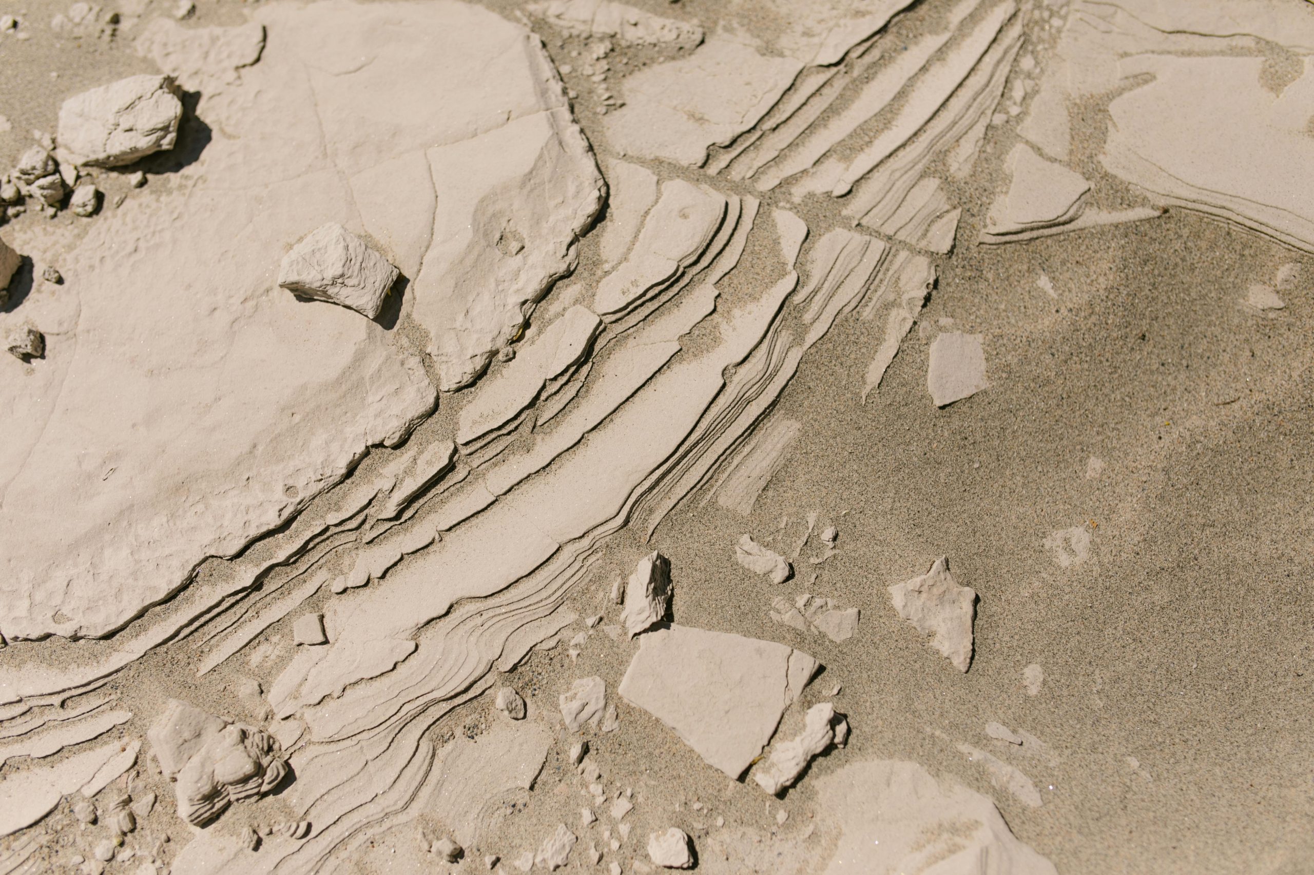 High-angle shot capturing intricate rock layers and sandy texture in an arid landscape.
